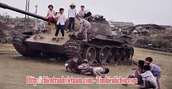 Trẻ em chơi đùa bên chiếc xe tăng T-54 quân Bắc Việt bị phá hủy trong trận An Lộc trong Mùa Hè Đỏ Lửa, chiến dịch Nguyễn Huệ, chiến dịch Xuân Hè trong chiến tranh Việt Nam - Children were playing around NVA T-54 tank was destroyed in battle of An Loc , Easter Offensive in Vietnam war